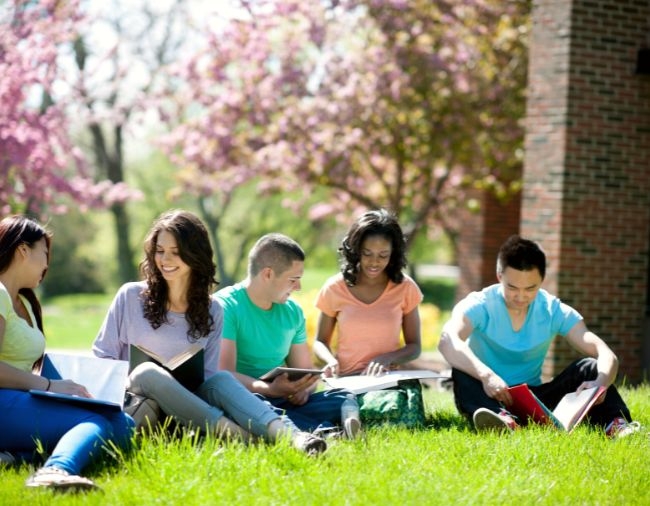 Diverse Students sitting outside on campus