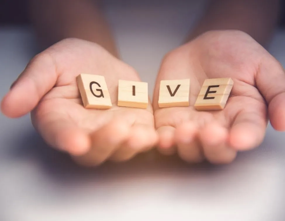 hands with give wooden letter tiles