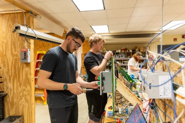 Two Electrical Technology Students Working on a Electrical Wire